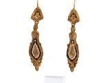 une paire de boucles d'oreilles en or ornées de motifs noirs et blancs