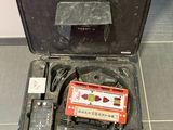 un étui noir contenant une cassette, posé par terre