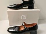 the woman ' s black shoes are sitting on top of a box