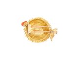 an image of a close up of a gold plate with a bird on it