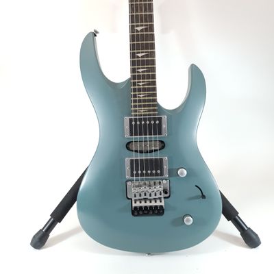 an electric guitar sitting on top of a stand on a white surface