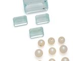 un assortiment de perles et un morceau de verre sur un fond blanc