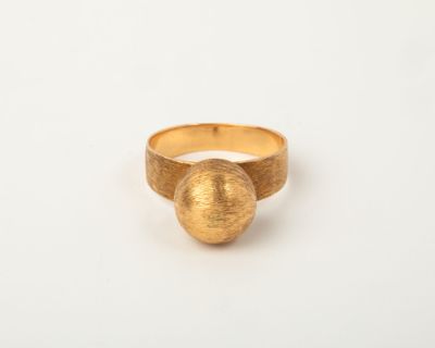 a close up of a gold ring on a white surface