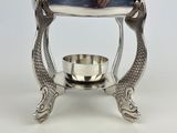 a silver plate with two fish legs and a bowl on top of it