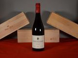 a bottle of wine sitting on a table next to two wooden boxes