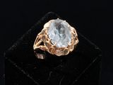 a close up of a gold ring with a blue topaz stone