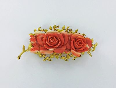 une photo d'une broche ornée de trois roses