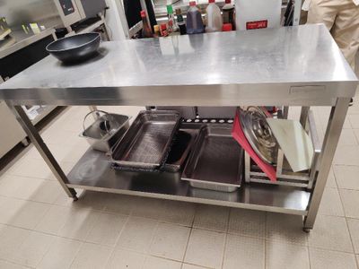 une table en acier inoxydable sur laquelle sont posés deux récipients