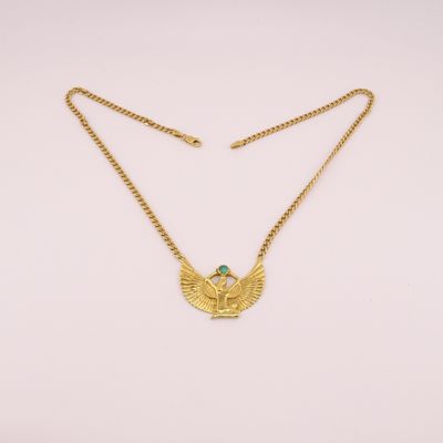 a gold necklace with a green stone on it