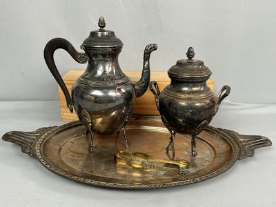 deux théières en argent posées sur un plateau en argent, sur une table