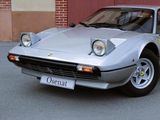 a silver sports car parked in front of a brick building