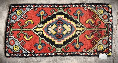 a close up of a rug on a floor with a tag on it