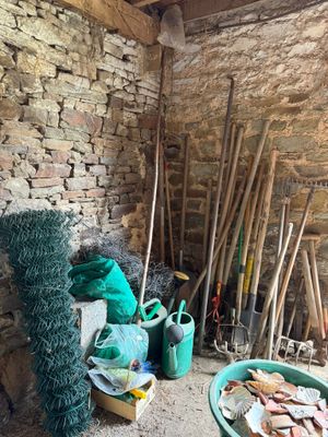 un tas d'outils de jardinage dans un coin de la pièce