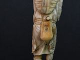 carved ivory figurine of a man carrying a bag