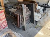 a pile of junk in a garage next to a pile of boxes