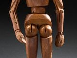 a wooden figure that is standing in the dark