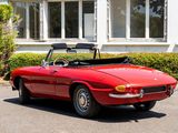 a red convertible car parked in front of a white house