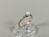 a ring with a pearl and a diamond on it