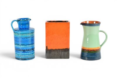 trois vases de couleurs différentes posés les uns à côté des autres sur une surface blanche
