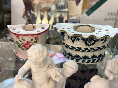 une vitrine en verre sur laquelle sont posés une tasse et une statuette