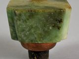 a close up of a small green object on a white surface