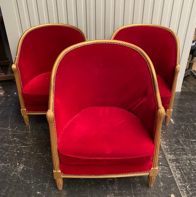 pair of red chairs with gold trim and wood legs