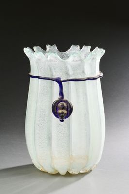 un vase blanc avec une anse bleue posé sur une table