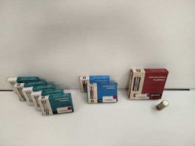 Plusieurs paquets de cigarettes sont alignés sur une surface blanche
