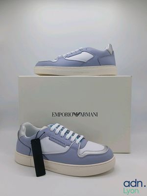 a pair of blue and white sneakers sitting on top of a box