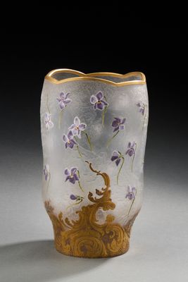 un vase en verre orné de fleurs violettes, posé sur une table