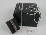 une boîte noire contenant un collier argenté et un portefeuille noir