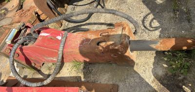 une photo d'une machine rouge et noire et de quelques outils