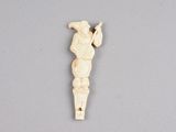an ivory figurine of a man holding a baseball bat on a gray surface
