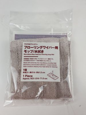 un gros plan d'un sac en tissu posé sur une surface blanche