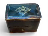 une petite boîte bleue ornée d'un motif doré