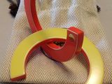 une paire de boucles d'oreilles créoles en acrylique rouge et jaune posées sur un sac