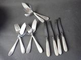 five forks and five knives on a table