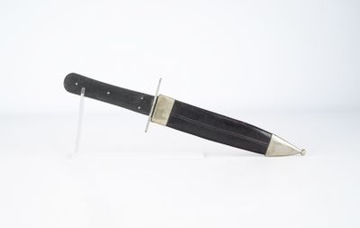 un couteau posé sur un support, sur une surface blanche