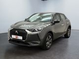 the front view of a grey car in a showroom