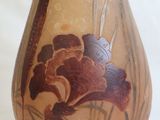 a vase with a flower painted on it sitting on a table