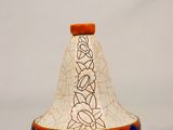 un petit vase orné d'un motif, posé sur une table