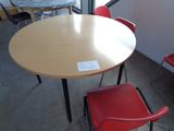 a table and chairs in a room with a sign on the table