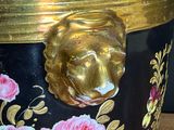 a black and gold vase with a lion head on it