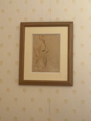 une photo d'un tableau accroché au mur au-dessus des toilettes