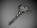 a heart shaped bottle opener on a gray surface