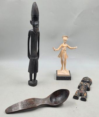 trois figurines en bois et une cuillère en bois posées sur une surface blanche