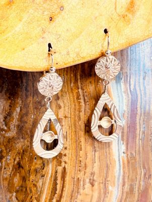 une paire de boucles d'oreilles posée sur un morceau de bois