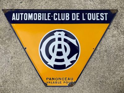 an orange and black sign on the side of a building that says automobile club de l ' quest