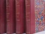 several red books are lined up in a row on a white surface