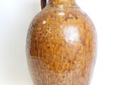 a brown vase that is sitting on a white surface